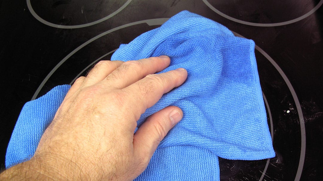 cleaning a glass-top stove with a Sollievo microfiber kitchen cloth
